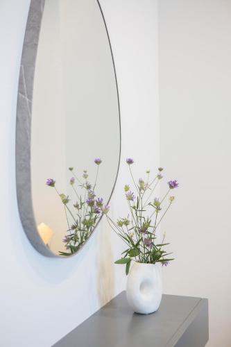 a white vase sitting on a table in front of a mirror at Emilia Villas in Agios Nikitas