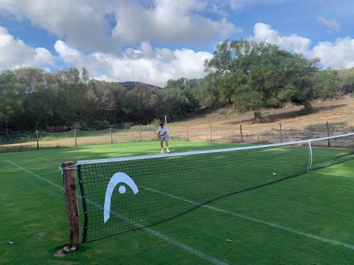 a person is standing on a tennis court at Stazzu Pittorra in Barrabisa