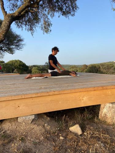 a man sitting on top of a wooden table at Stazzu Pittorra in Barrabisa