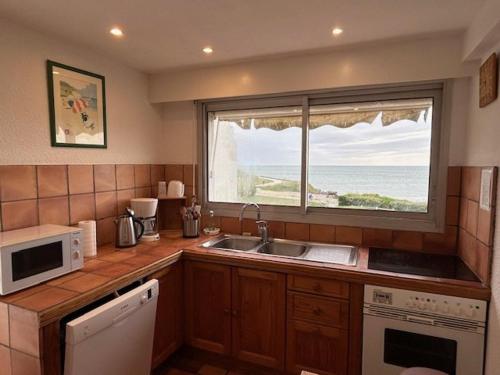 une cuisine avec un évier et une fenêtre dans l'établissement Appartement spacieux avec terrasses et parking à Royan - FR-1-494-73, à Royan