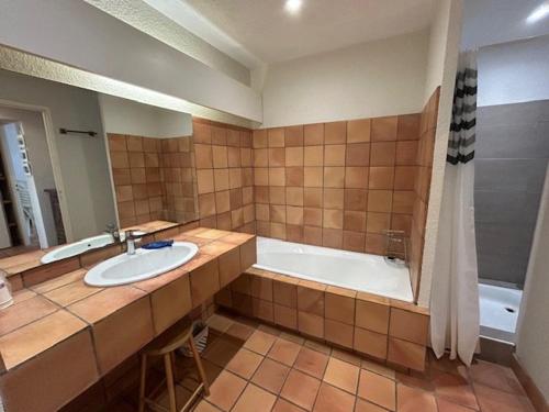 une salle de bain avec un lavabo et une baignoire dans l'établissement Appartement spacieux avec terrasses et parking à Royan - FR-1-494-73, à Royan