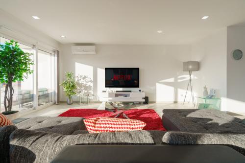 a living room with a couch and a flat screen tv at Eden Villa, with jacuzzi and ocean view in Casal do Cigano