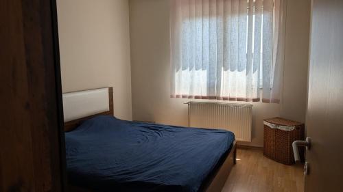 a small bedroom with a bed and a window at Cozy apartment in Prishtinë