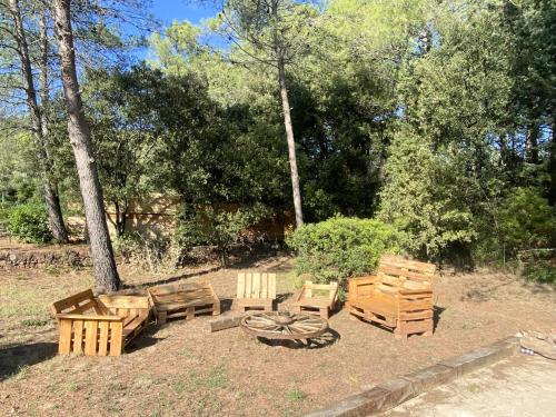 un groupe de bancs en bois et une table et des chaises dans l'établissement Villa 12 personnes au calme avec piscine, à Puget-Ville
