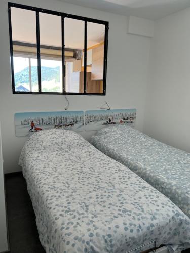 deux lits côte à côte dans une chambre dans l'établissement Le Furon, à Prénatier