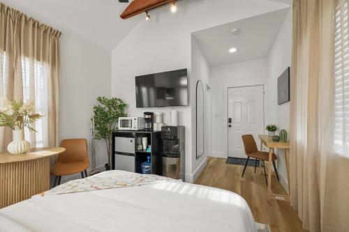 a bedroom with a bed and a table and a kitchen at Loft Style Studio In The Heart of D'Arts District in Houston