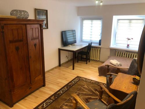 a living room with a table and a wooden cabinet at mieszkanie dwa pokoje centrum Rynek in Wrocław