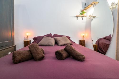 a purple bed with three pillows on it at Kharmen A 1565s House with Seaviews in Birgu