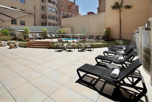 a row of lounge chairs and tables in a courtyard at HCC Montblanc in Barcelona