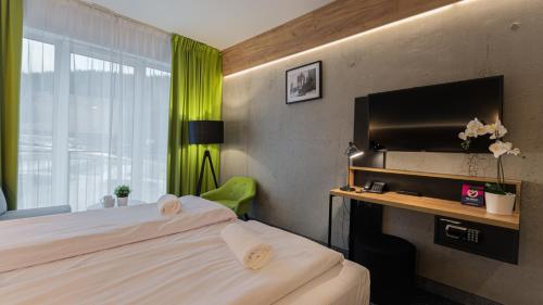 a hotel room with two beds and a television at VacationClub - Czarna Perła Apartament 514 in Sienna