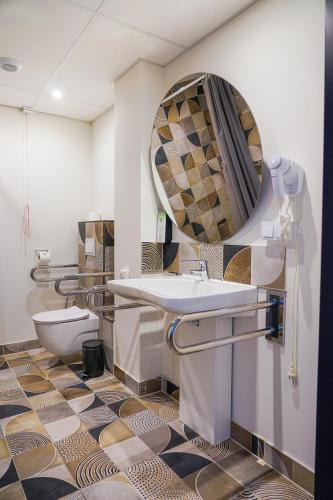 a bathroom with a sink and a toilet and a mirror at Hotel Convictus Cracovia for business & travellers in Kraków