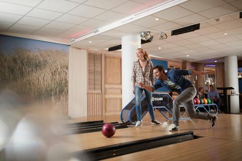 a man and a woman playing a game of bowling at WestCord Hotel Schylge in West-Terschelling