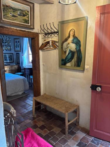 a room with a painting of a woman on the wall at Le grand Moulin in Pernay