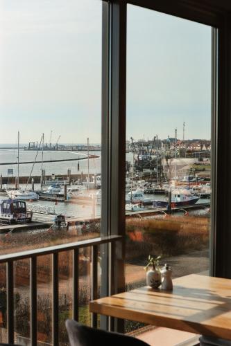 a view of a marina from a window at WestCord Hotel Schylge in West-Terschelling