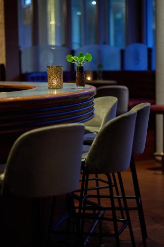 a table and chairs with plates and a plant on it at WestCord Hotel Schylge in West-Terschelling