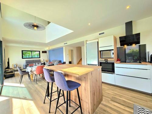 une cuisine avec une table et des chaises dans une pièce dans l'établissement La Saline - Villa avec piscine à 450m des Plages, à Le Tour-du-Parc
