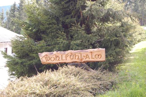 ein Schild auf einem Baum vor einem Busch in der Unterkunft Wohlfühl-Alm in Witra