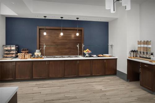 ポーツマスにあるHilton Garden Inn Portsmouth Downtownの青い壁の広いキッチン(木製キャビネット付)