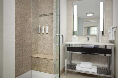 un baño con ducha y lavabo en Hilton Garden Inn Portsmouth Downtown, en Portsmouth