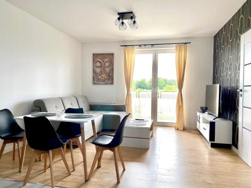 a living room with a dining table and chairs at Apartament Krakowska - winda, parking in Ostrów Wielkopolski