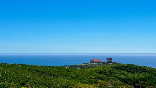 a house on top of a hill near the ocean at Coastal Breeze Villa in Sesimbra in Sesimbra