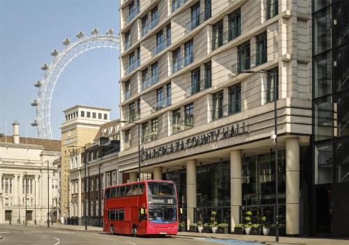 a red double decker bus parked in front of a building at Park Plaza County Hall London in London