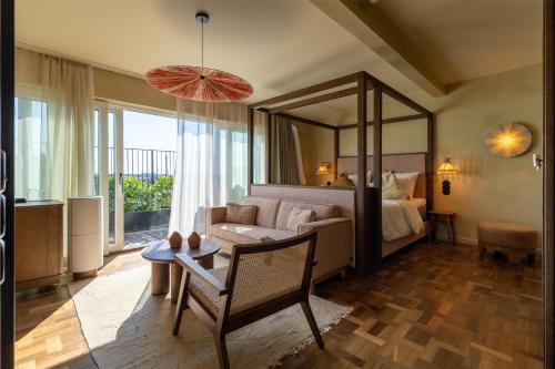 a room with a bed and a couch and a mirror at NH Copenhagen Grand Joanne in Copenhagen