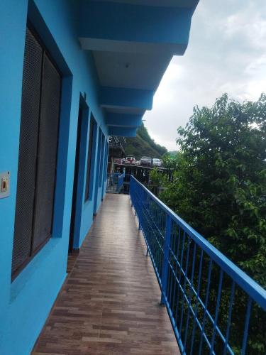 a balcony of a blue building with a wooden walkway at Sheetal Restaurant in Mussoorie
