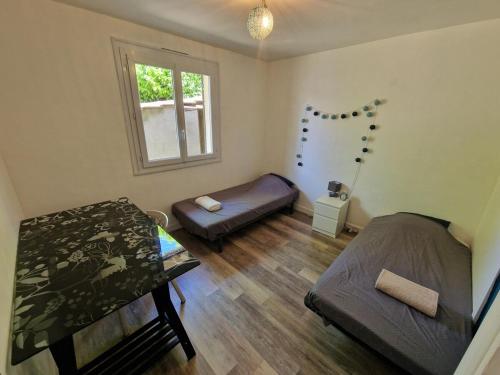 a small room with two beds and a window at Spacious and modern home 8 guests à Juvignac in Juvignac