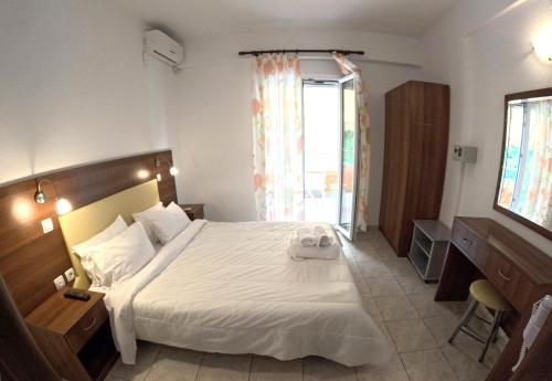a hotel room with a bed and a window at Eleni Kandilari Rooms in Kókkinon Nerón