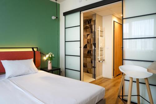 a bedroom with a white bed and a glass closet at Hotel Convictus Cracovia for business & travellers in Kraków