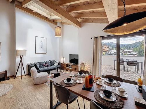 un salon avec une table, des chaises et un canapé dans l'établissement Celadon - appartement- 4 pers - proche centre, aux Gets