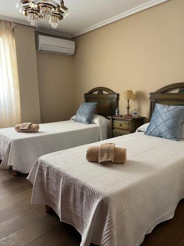 a bedroom with two beds with towels on them at Apartamento centrico en edificio histórico in Albacete