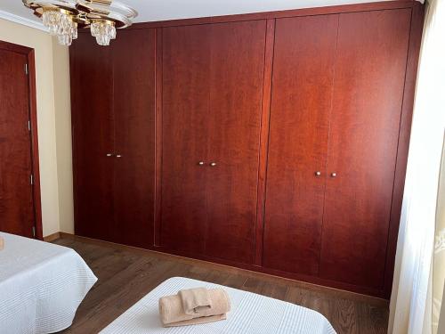 a bedroom with wooden cabinets and a bed with a towel at Apartamento centrico en edificio histórico in Albacete