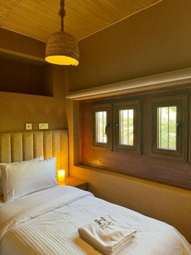 a bedroom with a bed with two towels on it at Aldar Inn in Nizwa