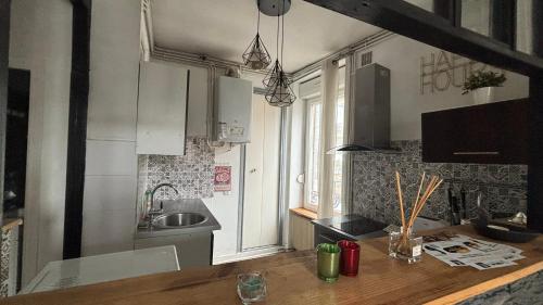 une cuisine avec un évier et un plan de travail dans l'établissement Charmant cocon tout équipé, à Clermont-Ferrand