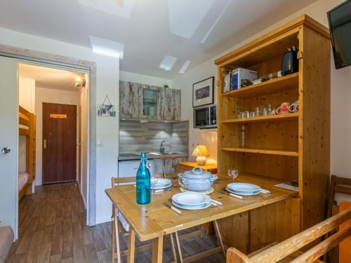 une cuisine avec une table en bois et des plaques de cuisson. dans l'établissement Studio rénové avec balcon, parking et proche pistes à Val-d'Isère - FR-1-694-287, à Val dʼIsère