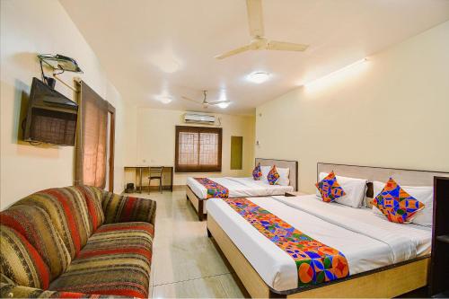 a hotel room with two beds and a couch at FabHotel Kamala Inn in Kotrung