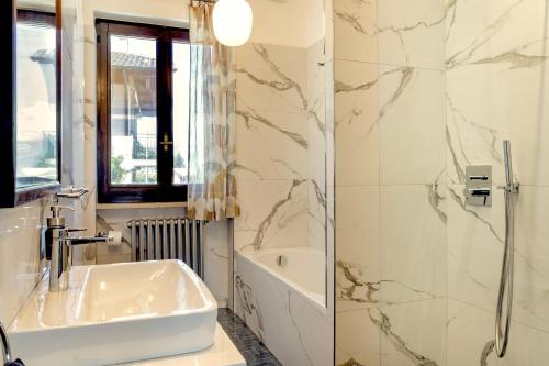 a white bathroom with a sink and a shower at Villa LM - Private Villa, Lake View, Salt Pool in Belgirate