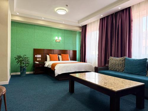 una camera d'albergo con un letto e un divano di New World Hotel a Ulaanbaatar