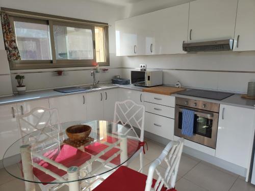 eine Küche mit einem Glastisch und Stühlen in der Unterkunft KALI - Apartment Tenerife Sur in Alcalá
