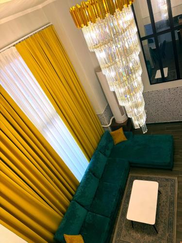 a living room with a green couch and a window at Andor Luxury Hotel & Duplex in Durrës