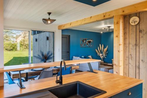 une cuisine et une salle à manger avec des murs bleus et un évier dans l'établissement Altitude Marine property, à Sibiril