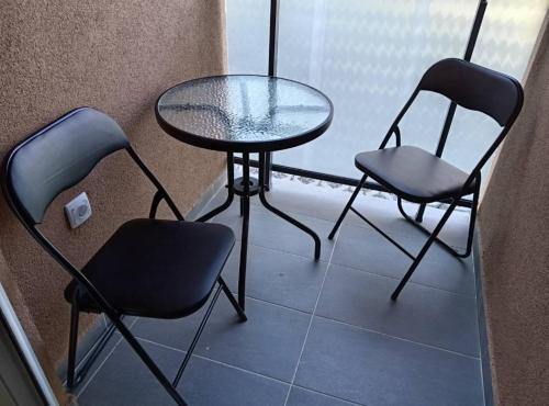 a table and two chairs and a glass table and chairs at Apartman Višnja in Gornja Toplica