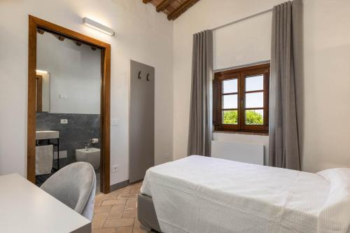 a bedroom with a white bed and a bathroom at B&B Panizzi - San Gimignano in San Gimignano