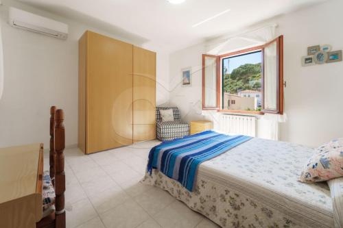 a bedroom with a bed and a window at La Rondine su Seccheto - Goelba in Seccheto