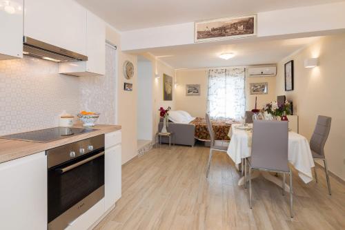 a kitchen and dining room with a table and a room at Apartments Dujam without terrace in Split