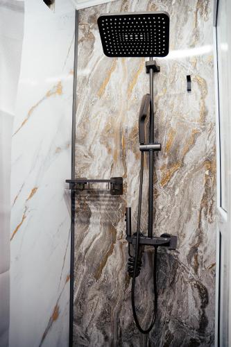 a shower in a bathroom with a stone wall at Хостел 1377 in Astana
