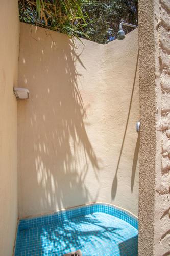 a shadow of a tree on a wall with a pool at Case Vacanze Maluk in Lampedusa