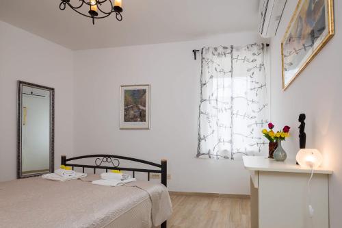 a bedroom with a bed and a mirror and a window at Apartments Dujam without terrace in Split